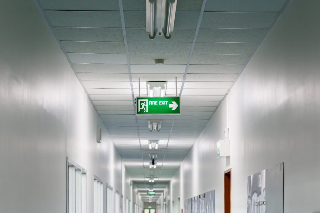 Emergency lighting exit sign in a factory setting