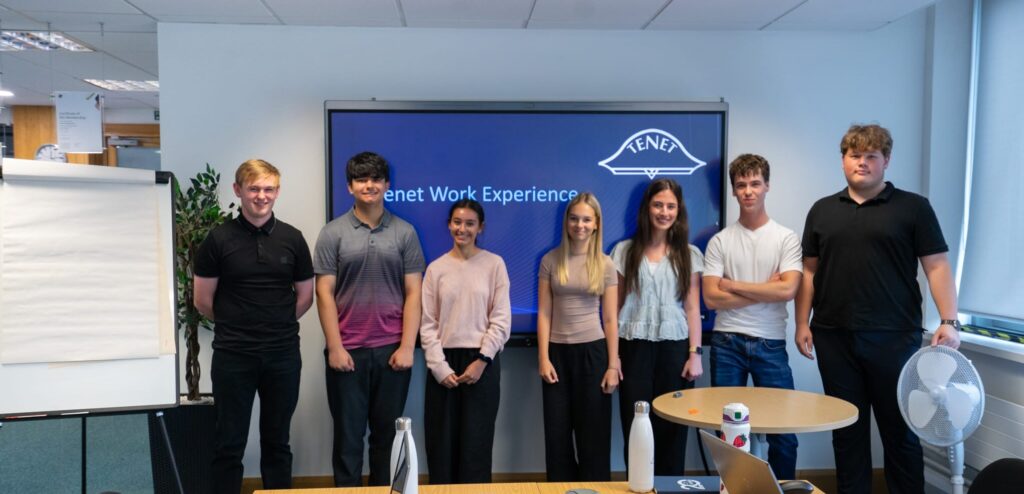 Work Experience Students stand in front of their presentation in the board room